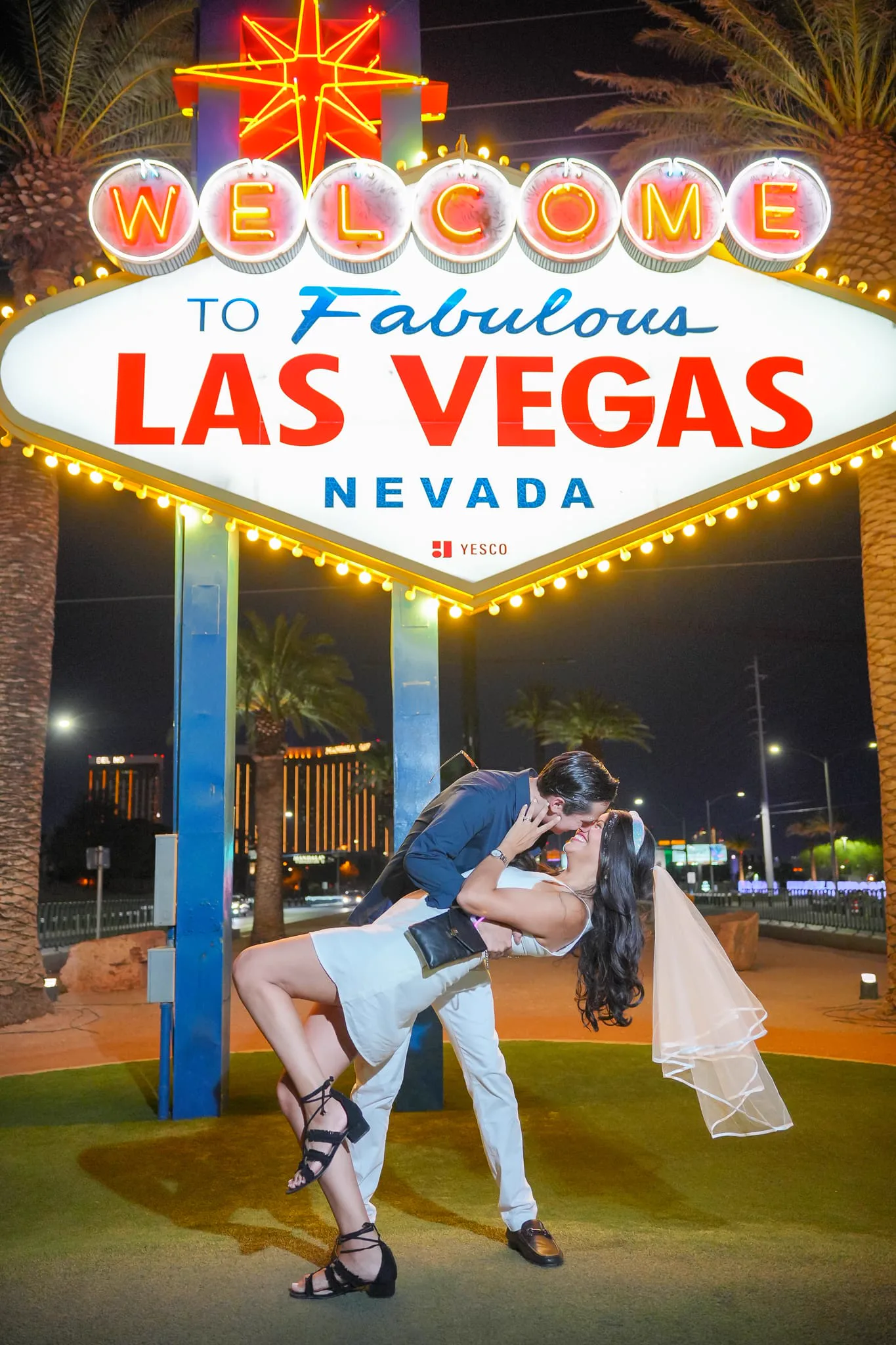 Couple at the Las Vegas Sign with a GXP Tours party bus